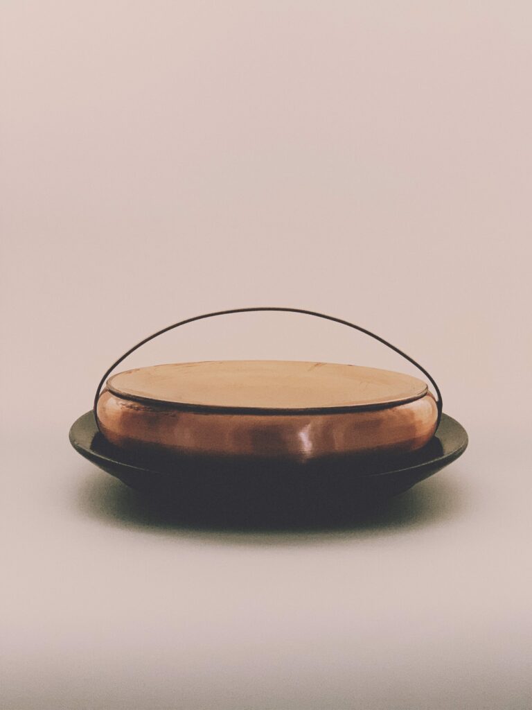 Handspun copper basket with a hand carved karappu kal granite base